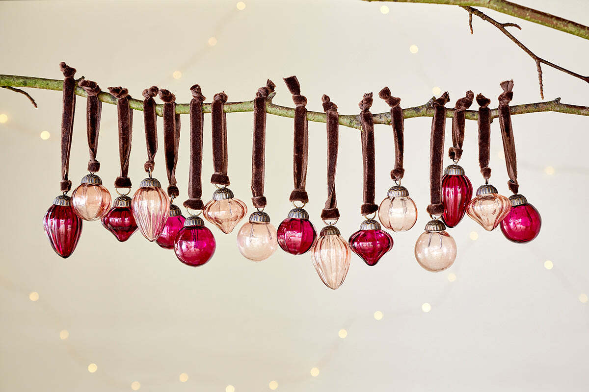The nkuku Adisa Bauble Jar - Ruby & Copper (Set of 16) brings festive charm to any branch with its mini baubles.