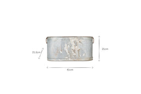 The Akasa Trough Planter - Zinc by nkuku is an oval, distressed metal tub with rust spots, peeling paint, and two small side handles. It measures 41 cm wide, 21 cm high (handle height 21.5 cm), shown on a plain white background.