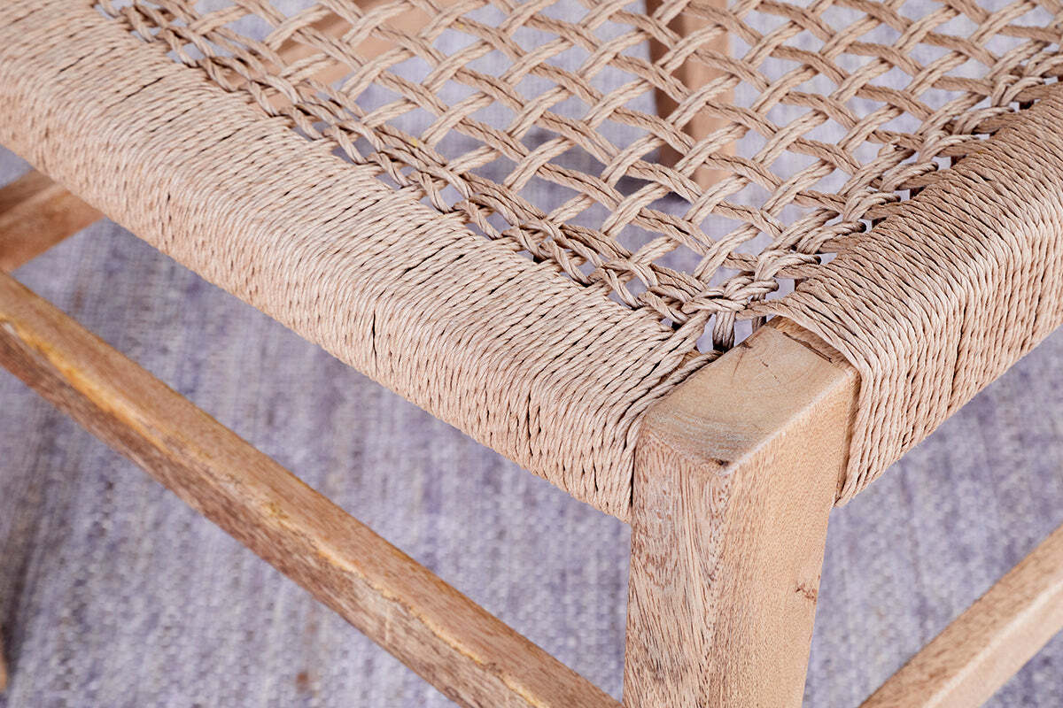 Close-up of the Aamani Mango Wood & Cord Dining Chair by nkuku, showing its natural mango wood frame with visible grain and a tightly woven cord seat in a textured crisscross pattern. The chair sits on a light, textured floor.