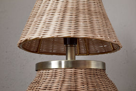 The Cija Rattan Table Lamp by nkuku features a natural woven shade and base, accented with a metallic band and stem—perfect for adding style to any bedside table.