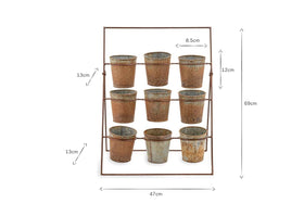 The nkuku Abari Planter Stand holds nine aged zinc pots in three rows. Measuring 69 cm tall and 47 cm wide, its rustic, distressed finish makes it ideal vintage-style garden decor.