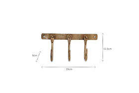 The nkuku Kuna Iron Hooks - Antique Brass is a brass-colored hook rack with three iron hooks on a horizontal bar, perfect for organizing small items. Dimensions: 23cm W x 11.5cm H x 6cm D.