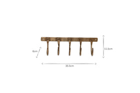 The nkuku Kuna Iron Hooks - Antique Brass features five antique brass-finished hooks on a rectangular plate, ideal for small storage. The rack measures 35.5cm wide by 8cm high; each hook is 11.5cm long.