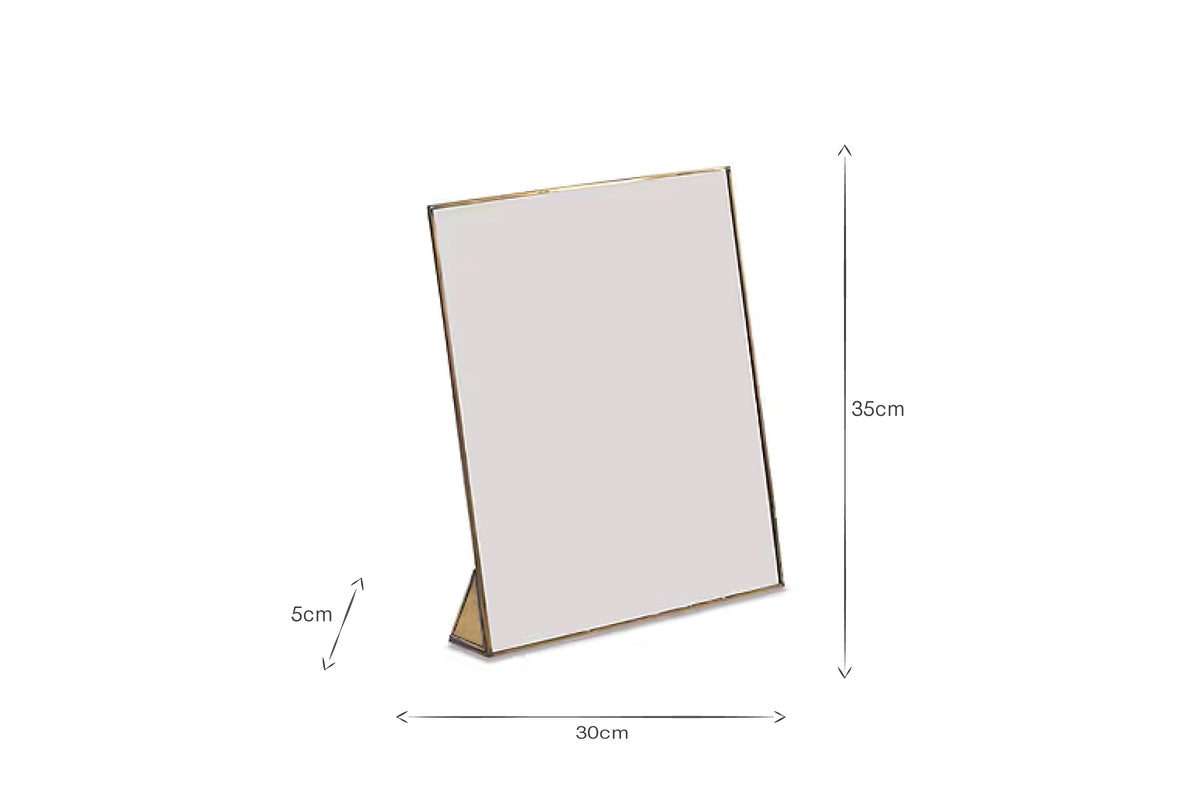 A rectangular tabletop mirror with a slim gold frame (35 cm tall, 30 cm wide, 5 cm stand) stands upright on a white background—perfect placed beside nkuku’s Karuma Ceramic Mug - Small (Set of 2) or other handmade mugs.
