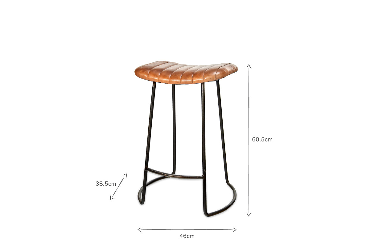 The Narwana Ribbed Leather Stool - Aged Tan - Small by nkuku features a brown ribbed leather saddle seat on a black metal frame. Dimensions: height 60.5 cm, seat height 38.5 cm, width 46 cm. Ideal as a counter chair; shown on a white background.