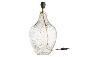 The Damini Recycled Glass Table Lamp by nkuku features a clear, bulbous base with a bubbled texture, brass neck, black socket, and visible cord. Crafted from recycled glass. Lampshade not included.