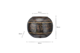 The nkuku Endo Reclaimed Iron Globe Planter is a round, dark brown pot (height: 34cm, width: 43cm, opening: 25cm) with horizontal bands and a distressed black iron finish. Measurement arrows shown. Displayed on a white background.