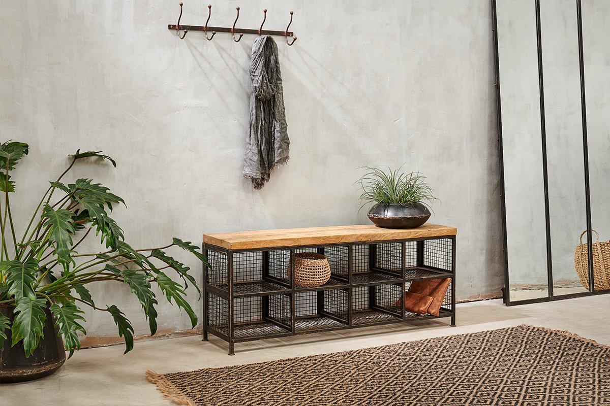 The nkuku Hasa Industrial Storage Bench features a mango wood top and wire mesh shelves for hallway storage. Perfect for plants on top, plus baskets or boots below, it combines urban style and function in your entryway.