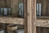 Close-up of the nkuku Ibo Reclaimed Wood & Glass Cabinet (Wide, Natural), displaying textured glass cups on upper shelves and black-patterned ceramic bowls and plates below.
