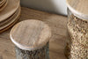 Two nkuku Igoko Storage Jars - Clear, with mango wood lids and filled with lentils, sit on a wooden surface beside stacked wooden plates, creating an elegant kitchen organizer.