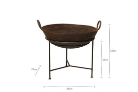The nkuku Reclaimed Iron Kadai With Grill - Medium features a rustic, weathered brown finish, grated top, two side handles, and tripod stand. Dimensions: 80cm wide, 32cm bowl height, total height 55cm. Perfect as a classic outdoor fire pit barbecue.