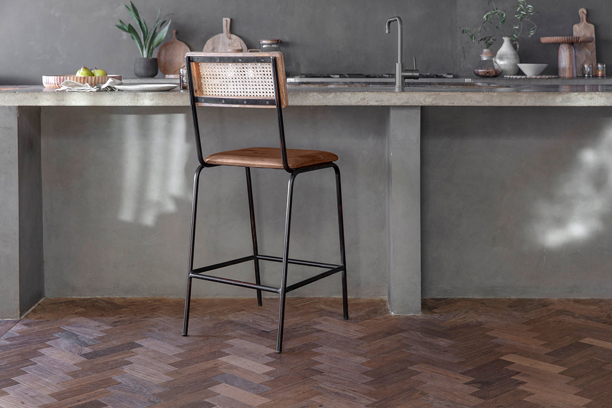 The Iswa Leather & Cane Counter Chair in aged tan by nkuku brings comfort and stylish elegance to your kitchen island with its chic cane back design.