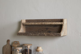 The nkuku Ibo Reclaimed Wood Storage Shelf - Natural adds rustic charm, mounted above a countertop with glass jars, a wooden cutting board, and a ceramic container—ideal for stylish kitchen storage.