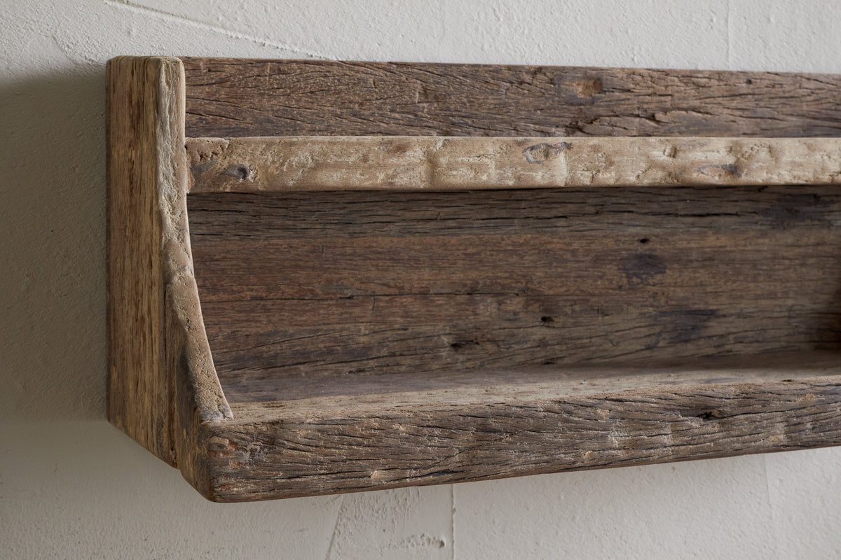 The nkuku Ibo Reclaimed Wood Storage Shelf - Natural adds charm and extra kitchen storage to any wall with its rustic, wall-hung design made from weathered wood.