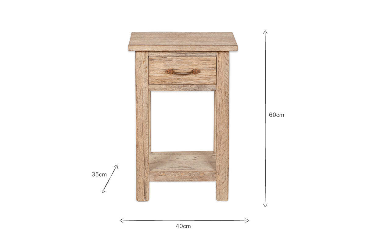 The Ibo Reclaimed Wood Bedside Table - Natural by nkuku is a rustic bedside table crafted from reclaimed wood, featuring one drawer with a dark metal pull, an open shelf below, and measures 60cm H x 40cm W x 35cm D.