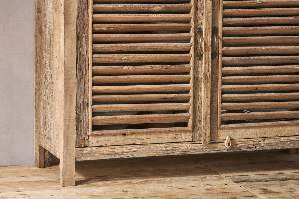 Close-up of the Ibo Reclaimed Wooden Slatted Sideboard by nkuku, featuring artisan-crafted louvered doors, weathered natural finish, ornate metal handles, and a small wooden latch accent on the lower panel.