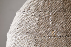 Close-up of the nkuku Jahari Woven Jute Pendant in Natural, featuring a dome-shaped design with coarse, woven burlap for visible texture—ideal for adding rustic charm to any home decor.