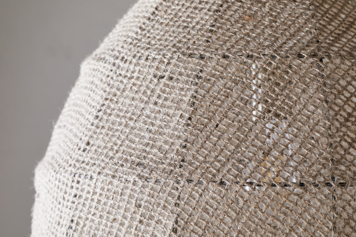 Close-up of the nkuku Jahari Woven Jute Pendant in Natural, featuring a dome-shaped design with coarse, woven burlap for visible texture—ideal for adding rustic charm to any home decor.