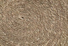 Close-up of the nkuku Keso Woven Placemats - Brown (Set of 4) reveals detailed circular and spiral patterns in natural fibers—perfect as a textured, handcrafted backdrop for minimalist tableware or handwoven coasters.