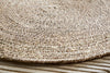 Close-up of the nkuku Keso Woven Placemats - Brown (Set of 4) on a wooden surface. Their handwoven texture adds charm and pairs perfectly with minimalist tableware.