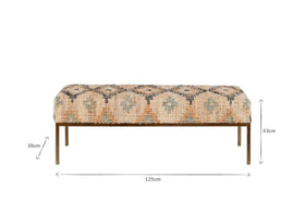 The Kesu Kilim & Iron Bench by nkuku features patterned beige and blue fabric, four slender iron legs, and measures 125cm wide, 38cm deep, and 43cm high. The front-facing image highlights its dimensions with measurement arrows.
