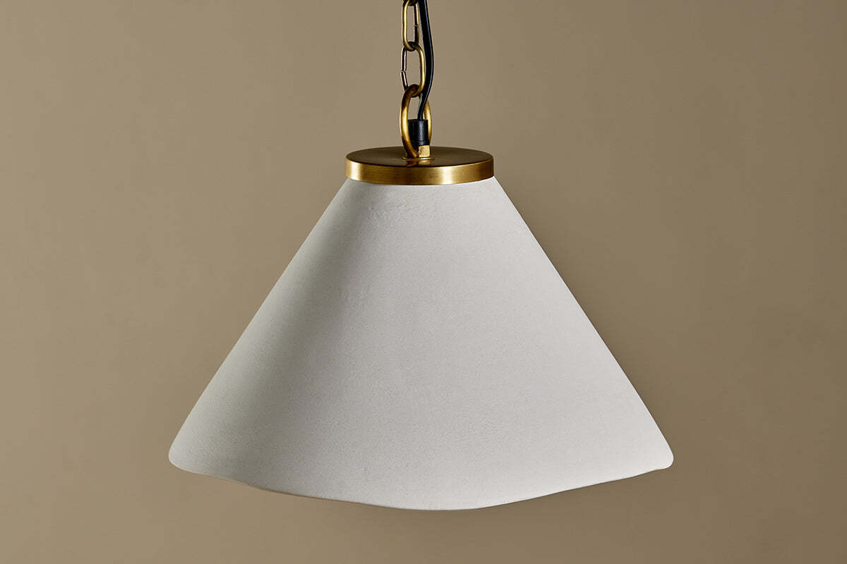 The Kiara Organic Shape Ceramic Pendant Light by nkuku features an off-white, asymmetrical shade and antique brass fixture, offering handcrafted elegance and stylish lighting to any space.