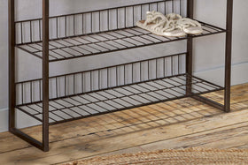 The nkuku Kiyoma Iron & Wood Tall Standing Shelves - Natural features three metal and wood shelves against a light wall. Braided rope slippers sit neatly on the top shelf, while the bottom shelf remains empty, lending an industrial touch to the space.
