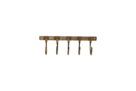The nkuku Kuna Iron Hooks in antique brass offer five wall-mounted hooks with rounded ends for compact storage. An industrial vintage look is highlighted by a sturdy bar and end screw holes for secure mounting.