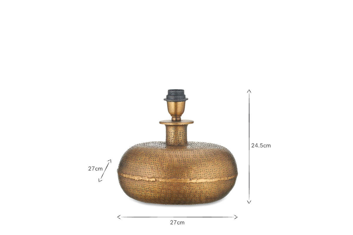 The nkuku Lumbu Lamp - Antique Brass (Small) features a round, textured artisan base with central neck and bulb holder. Dimensions: 27cm W x 27cm D x 24.5cm H. Shown on a white background with black arrows for size—ideal for decorative lighting.