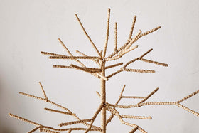 The nkuku Mala Base Jute Tree - Natural features many thin, woven jute branches and a minimalist leafless design, making it a textured, simple decor piece against any plain wall—perfect for festive decorating.