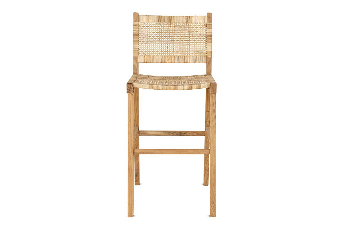 The Madrisana Acacia & Rattan Bar Stool by nkuku features a natural light acacia frame, woven rattan seat and rectangular backrest, straight legs, and a footrest bar. Its simple, modern design is shown against a white background.