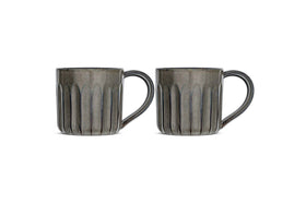 The Moda Mug - Pewter (Set of 2) by nkuku features two gray ceramic mugs with vertical ribbed texture, large rounded right handles, and glossy finish—all shown side by side against a white background.