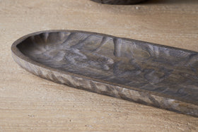 A close-up of the nkuku Nyati Serving Platter in dark brown, handcrafted from mango wood with an oval shape and textured patterns—an ideal piece for sustainable home decor.