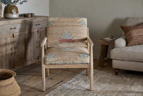 The Kavya Kilim Occasional Armchair - Natural by nkuku, crafted from mango wood, brings inviting warmth and rustic charm to any room.