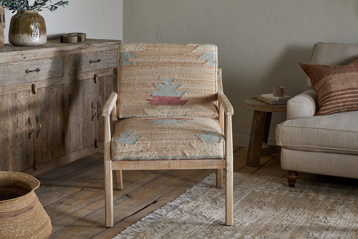 The Kavya Kilim Occasional Armchair - Natural by nkuku, crafted from mango wood, brings inviting warmth and rustic charm to any room.