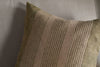 A close-up of the nkuku Eesha Jute Cushion Cover in Sage Green displays coarse, woven fabric with vertical beige and sage green stripes, resting on a light grey surface—perfect for adding charm to modern rustic decor.