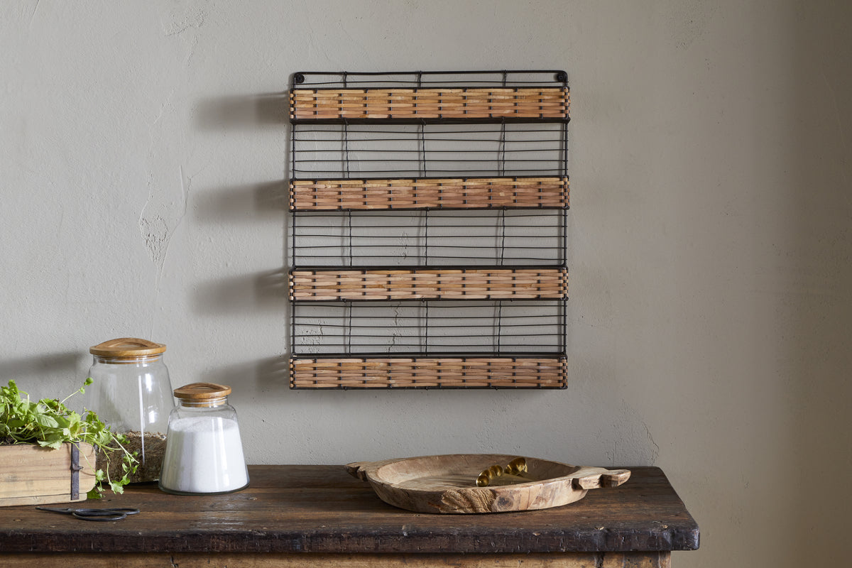 The Montali Iron & Rattan Spice Rack by nkuku adds rustic charm, perfect for kitchen storage or displaying spices alongside a wooden bowl and salt on your table.