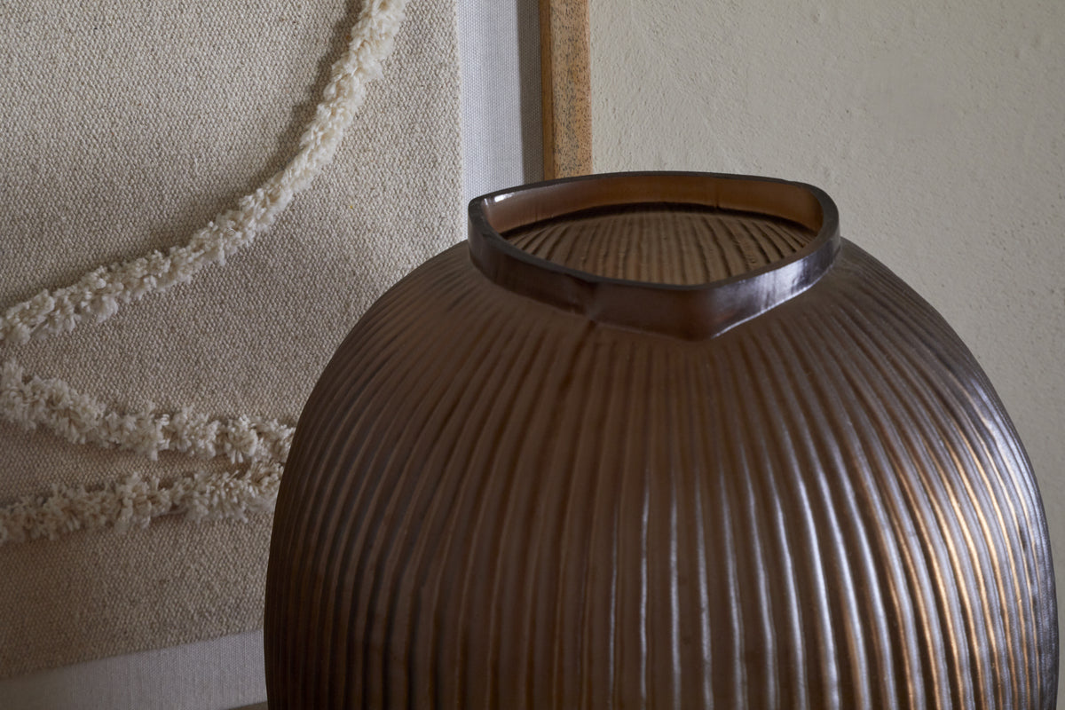 The nkuku Linsy Ribbed Glass Vase in Smoke Brown features elegant ribbing and a stylish smoked finish.