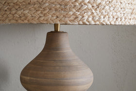 The nkuku Dalat Ceramic Table Lamp - Natural features a handcrafted design and white shade, bringing elegance to any room.