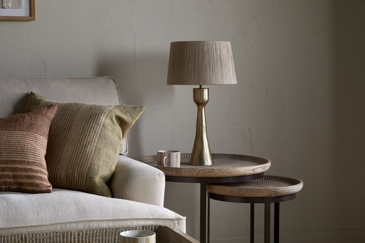The Marpha Antique Brass Table Lamp by nkuku sits elegantly on the bedside table, offering warm accent lighting to the room.