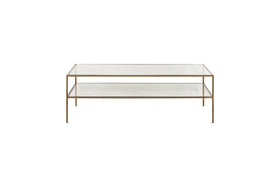 The Nakuru Iron & Glass Coffee Table by nkuku features a modern rectangular design with a slim gold metal frame, two clear glass surfaces (a top and lower shelf), and four slender legs, shown against a plain white background.