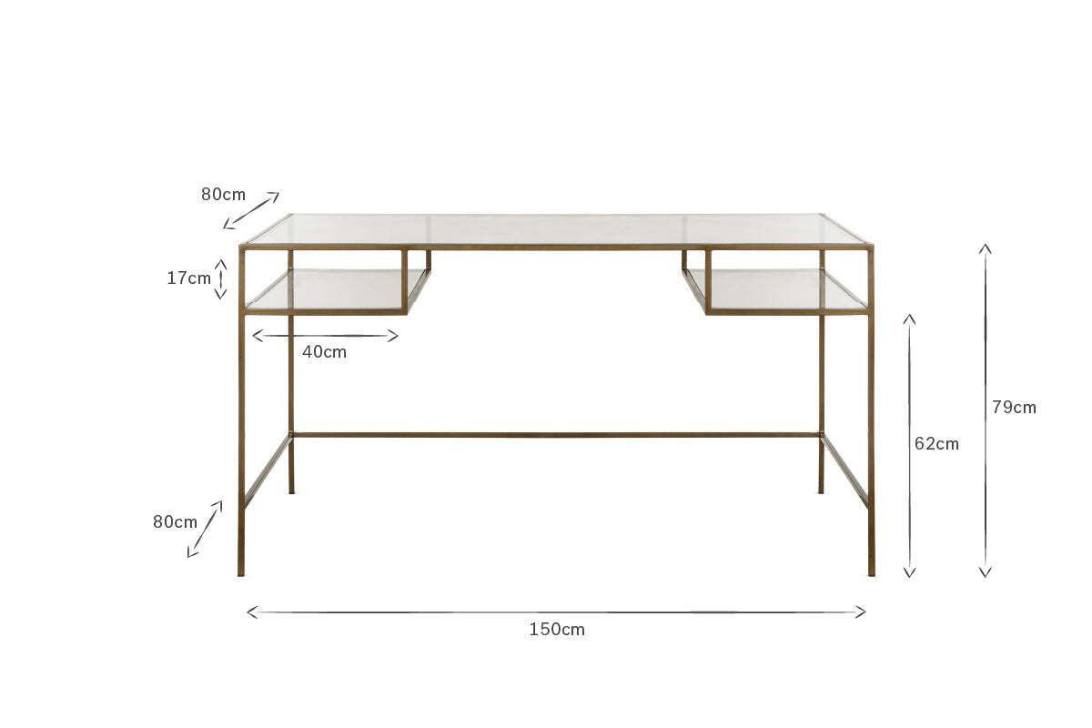 The Nakuru Iron & Glass Desk by nkuku features a modern glass top, slimline brass frame, and two shelf-like compartments. Ideal as stylish home office furniture. Dimensions: 150cm W x 79cm H x 80cm D with detailed shelving and leg measurements.