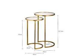 The nkuku Nakuru Iron & Glass Side Table Set - Brass includes two round nesting tables with glass tops and gold iron frames. Heights: 61.5cm and 55cm; base widths: 40cm and 30cm. Elegant and space-saving for any room.