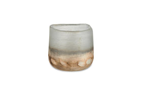 The nkuku Ngolo Tealight Holder - Aged Smoke is a small, cylindrical holder made from recycled glass. Its frosted surface fades from grayish-white to brown, and its irregular rim beautifully catches light against a white background.