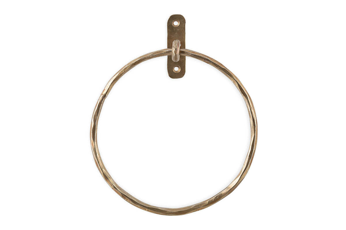 The Olani Towel Ring - Antique Brass by nkuku features a hammered brass finish and a rectangular wall plate with two screw holes, creating an elegant vertical towel holder perfect for any bathroom.