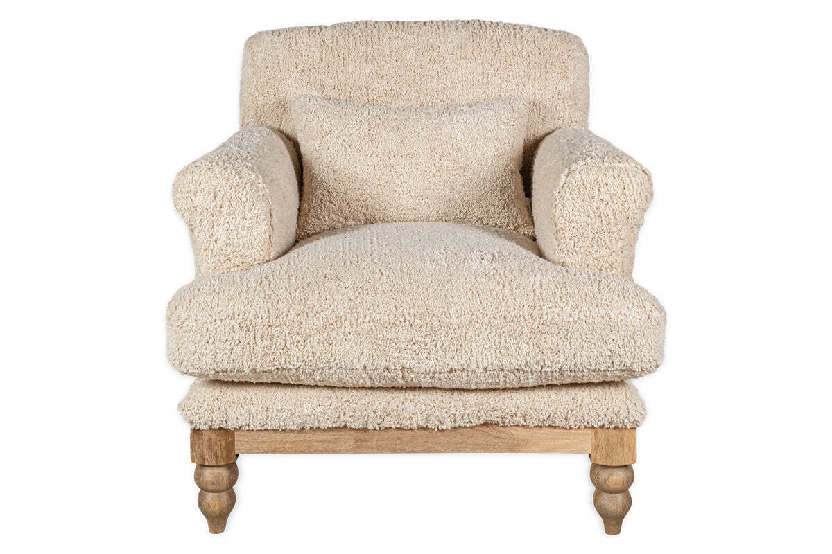 The nkuku Otas Teddy Cotton Armchair in off white features plush, textured fabric, thick rounded arms, a matching cushion, and four turned natural mango wood legs. The background is plain white.
