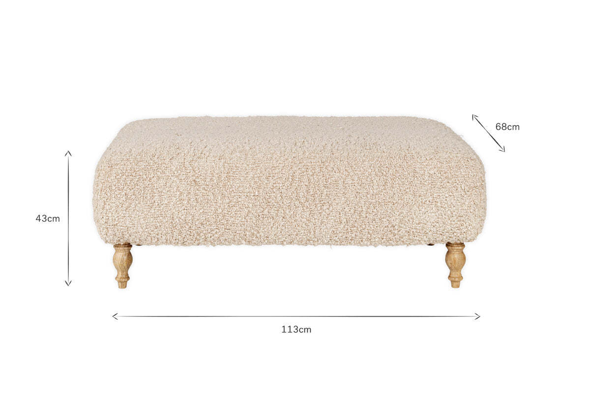 The Otas Teddy Ottoman - Off White by nkuku features fluffy, cream boucle upholstery, a solid mango wood base, and carved legs. Dimensions: 113cm W x 68cm D x 43cm H. A stylish blend of comfort and elegance for any space.