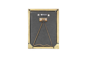 The nkuku Pambani Photo Frame - Antique Brass is a small rectangular frame featuring a brass border, metal corner protectors, a black back with a triangular stand, and a serrated hook for hanging. Photographed on a white background.