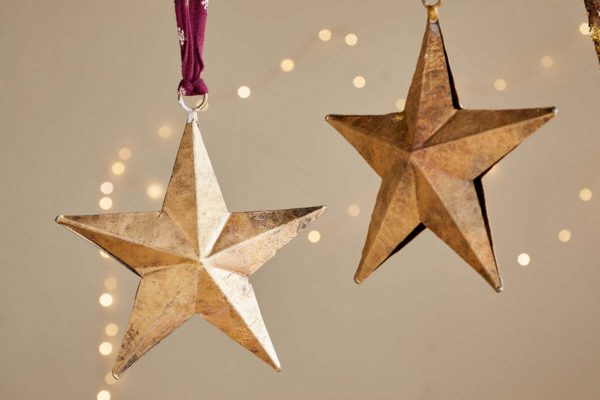 The Roshani Star Baubles - Antique Brass (Set of 2) by nkuku make a charming festive display.