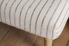 Close-up of the nkuku Sanja Stripe Upholstered Bench - Grey, showcasing cream and black striped natural cotton upholstery, a light wooden leg, and positioned on a wooden floor.